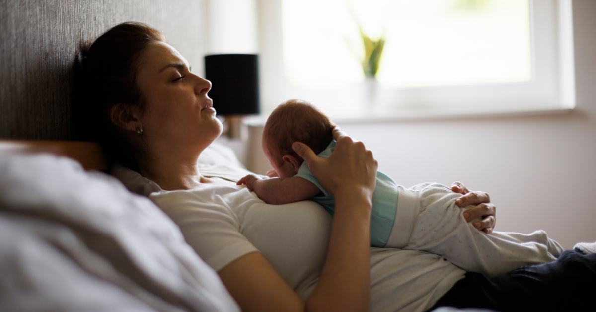 A newly postpartum mom holding her baby during the 4th trimester