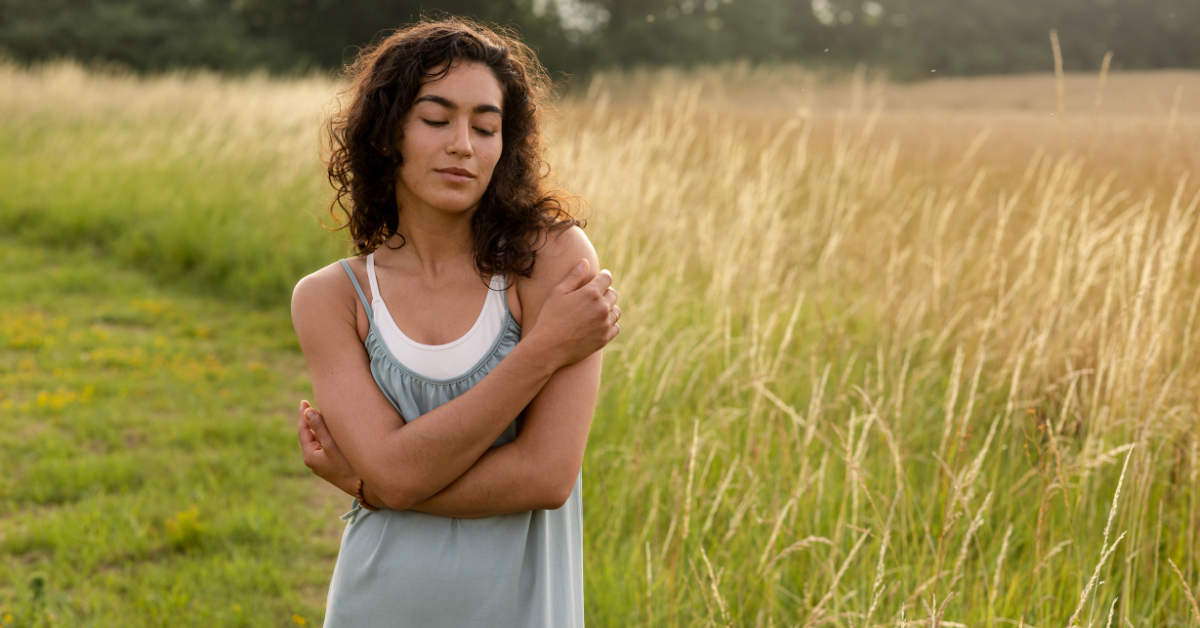 A mom standing outside taking a mindful moment to reconnect with herself and having self-care