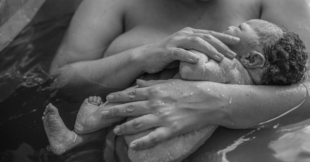 A woman who had a home water birth holding her newborn baby